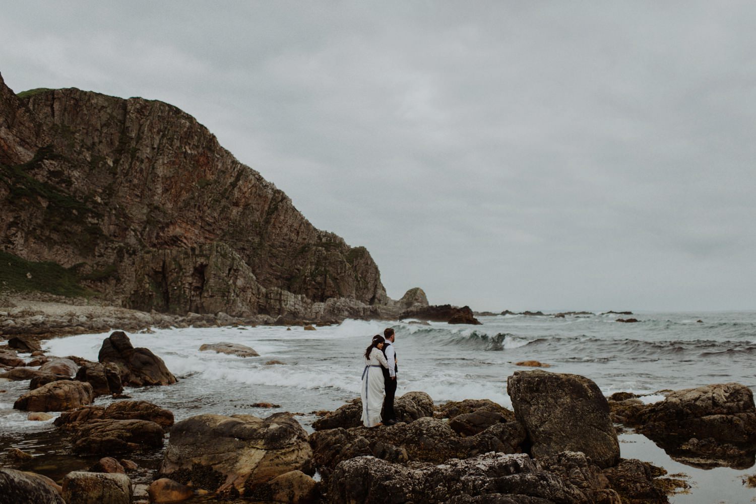 Bride and Groom standing on rocks