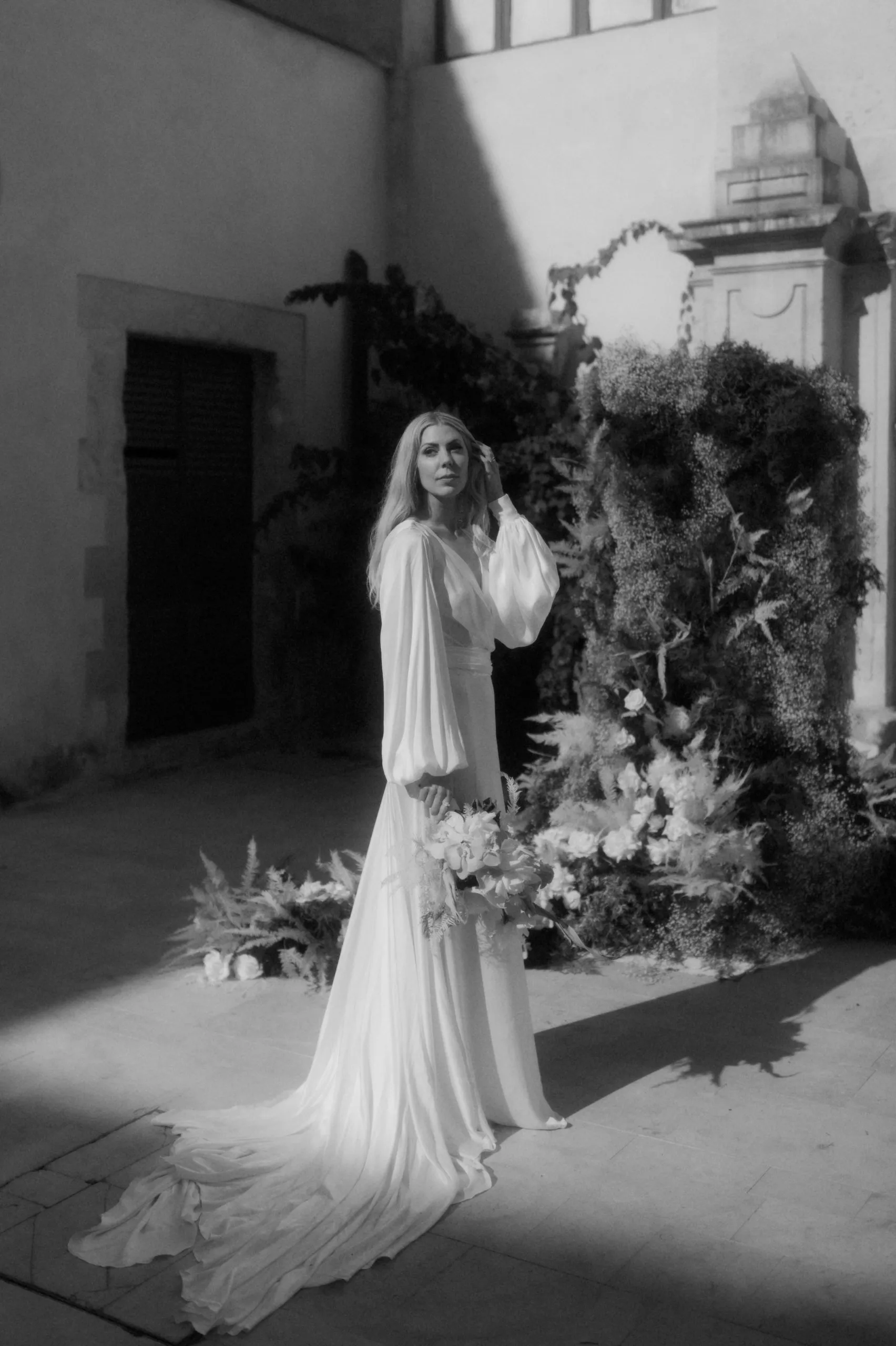 portrait of a bride standing alone holding a bouquet