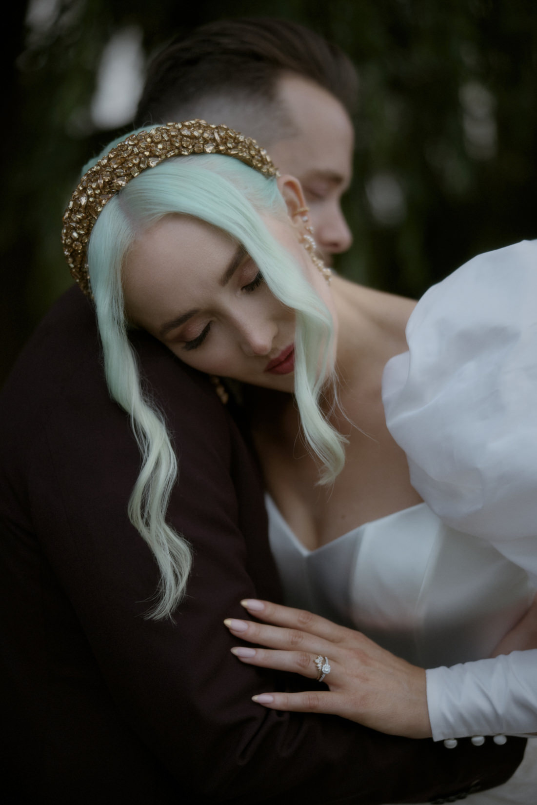 a bride with green hair hugging her groom